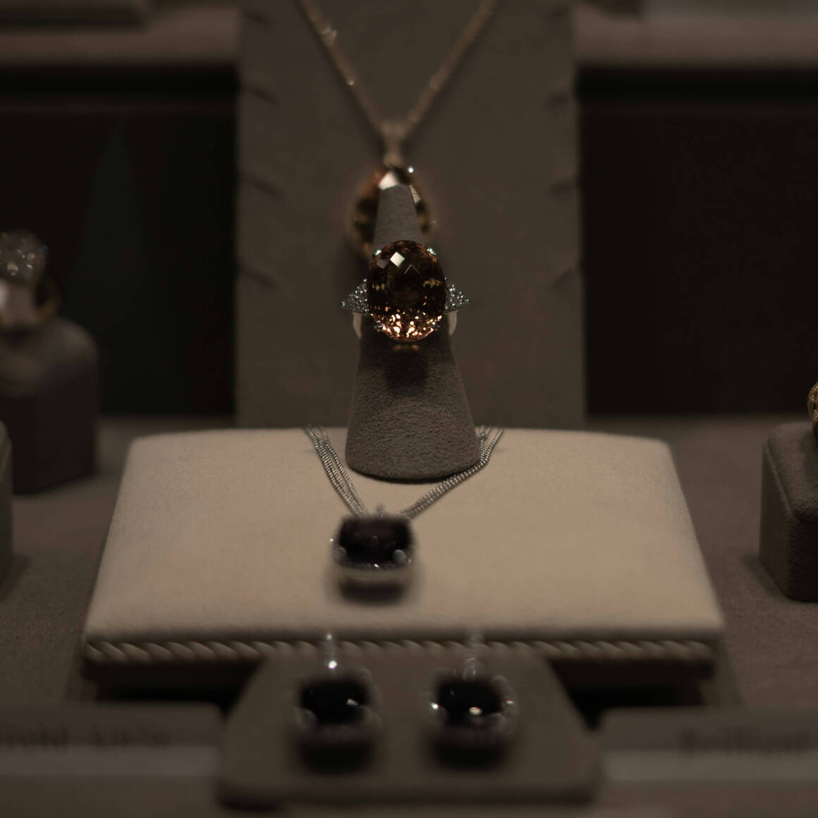 Display of black gemstone jewellery including a necklace and earrings with dark stones set in silver, showcased in a jewellery store.