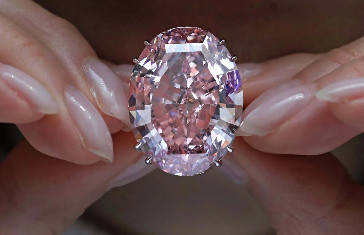 The Pink Star Diamond, a flawless, oval-cut pink diamond weighing 59.6 carats, displayed in a secure glass case, representing one of the most valuable gemstones that increase in value.