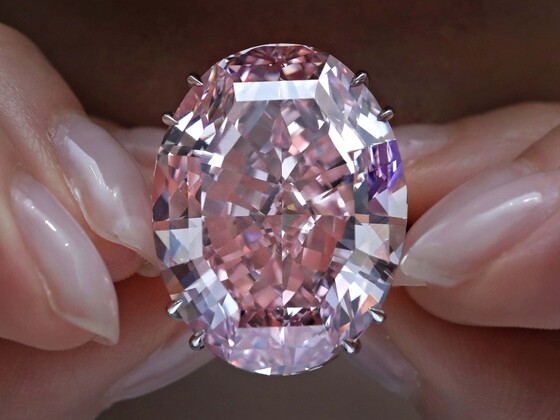 The Pink Star Diamond, a flawless, oval-cut pink diamond weighing 59.6 carats, displayed in a secure glass case, representing one of the most valuable gemstones that increase in value.