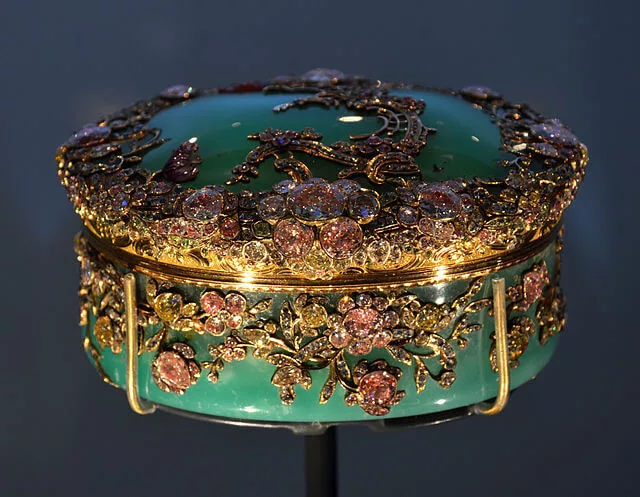 Ornate jewelry box featuring chrysoprase, the modern May birthstone, adorned with gold and gemstone floral designs.