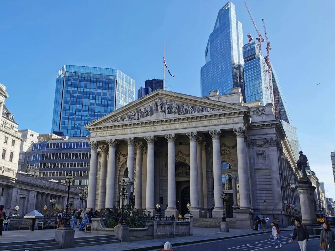 A view of the Bank of England and the Royal Exchange in London’s financial district, with modern skyscrapers in the background, symbolizing the historical and contemporary significance of metal investing in global finance.