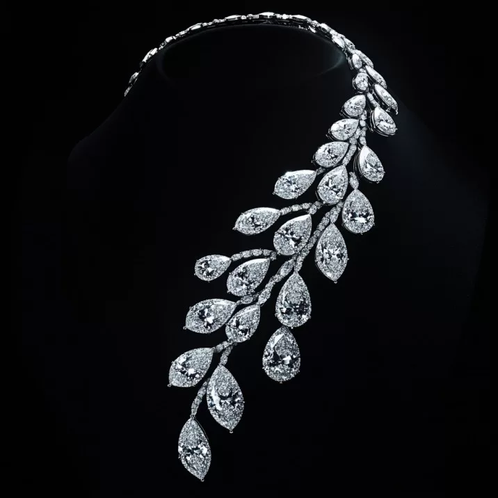An exquisite diamond necklace designed with AI, featuring an intricate, asymmetrical arrangement of pear-shaped diamonds resembling cascading leaves, set against a black background, showcasing the innovation of ai in jewellery design.