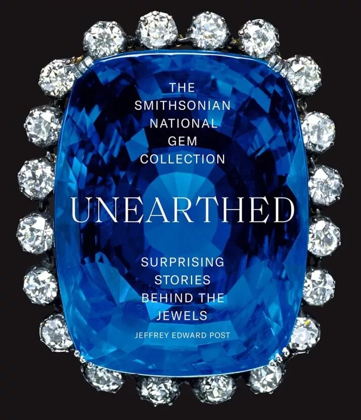 Book cover of "The Smithsonian National Gem Collection—Unearthed: Surprising Stories Behind the Jewels," featuring a glossy, faceted gemstone design and elegant typography, symbolizing the allure and intrigue of the world’s most famous jewels.
