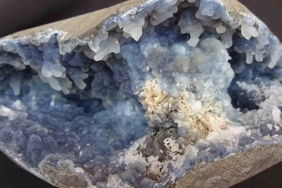 Chalcedony geode with blue and white crystal formations inside a partially open nodule.