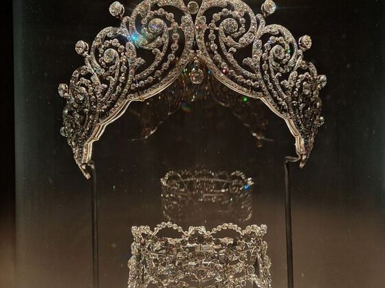 A sparkling diamond tiara on display at the Cartier exhibition at the V&A’s, intricately designed with swirling motifs—showcasing the artistry behind the tiara on display.
