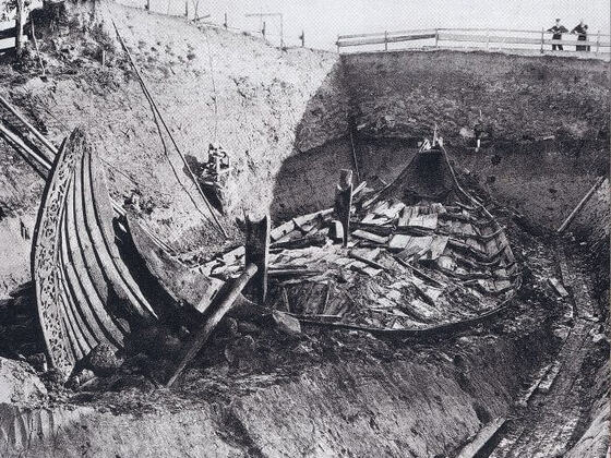 Black and white photograph of the Oseberg ship excavation in Norway, an elaborate Viking ship grave discovered in a burial mound, one of the most famous examples of Viking Burials.